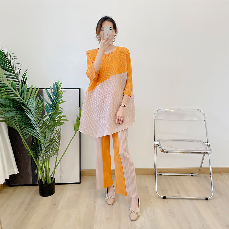 New color blocked seven quarter sleeve angled top with pleated suit and contrasting straight leg pants two-piece set