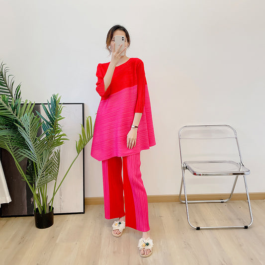 New color blocked seven quarter sleeve angled top with pleated suit and contrasting straight leg pants two-piece set